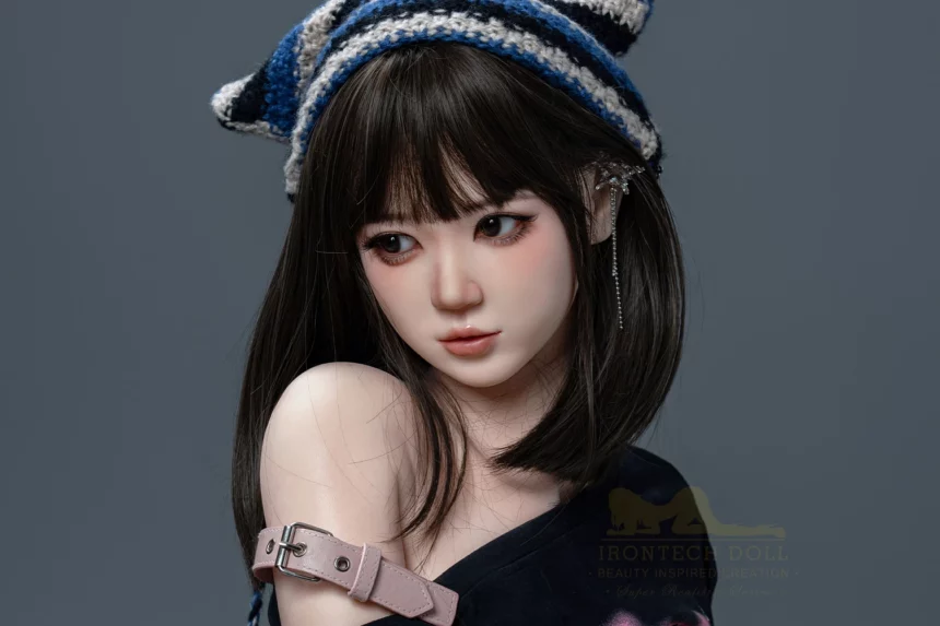 A realistic sex doll with long dark hair and bangs, wearing a striped knit hat and shoulder strap