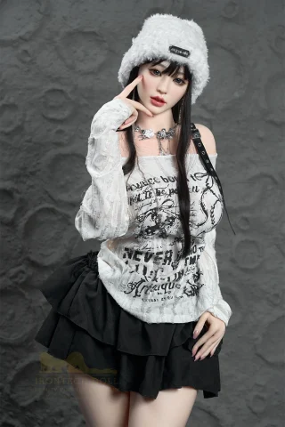 Luna Noir Wonder Dolly 158cm wears a white graphic top and a black ruffled skirt, with a fluffy white hat.