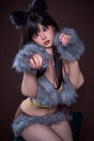 A doll with long black hair and cat-like ears, wearing a furry gray outfit, poses playfully with outstretched hands.
