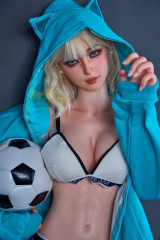 A figure in a teal hoodie with a hood up, holding a black and white soccer ball, wearing a cream-colored bra underneath.