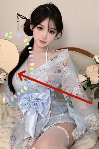 A young woman in a light blue kimono-style pajama with floral patterns, holding a fan, seated among roses.