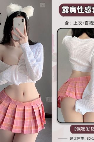 A model wears a sheer white cropped sweater and a pink plaid mini skirt, with playful cat ear accessories, posing in a soft, bright setting.