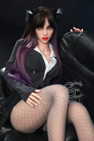 A seated doll with long, dark hair featuring purple highlights, wearing a gray blazer over a white shirt, and fishnet stockings.