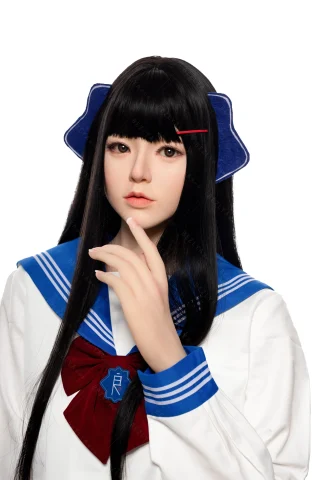 A doll with long black hair, wearing a white sailor-style uniform with a blue collar and a red bow, poses thoughtfully.