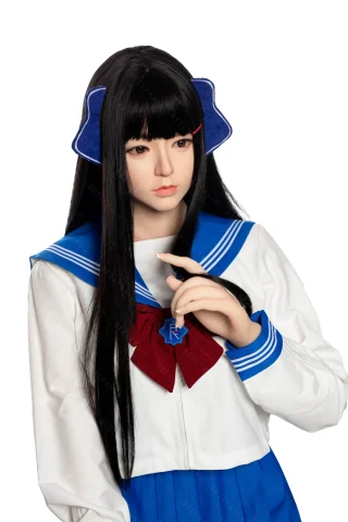 A doll with long black hair, wearing a white sailor-style school uniform with blue accents and a red bow, poses thoughtfully.