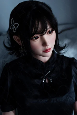 A doll with dark hair styled in soft waves, wearing a black cheongsam, adorned with a butterfly hairpin and subtle makeup.