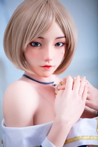 A close-up of a doll with short blonde hair, soft facial features, and blue eyes, wearing a white outfit with a choker.