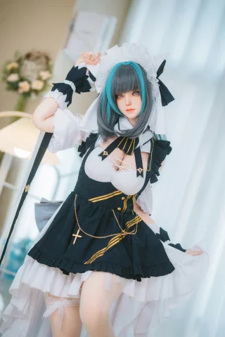 A doll dressed in a black and white maid outfit with a frilly skirt, lace accents, and a cross necklace, featuring teal hair.