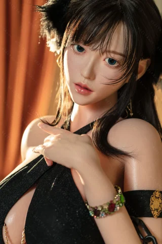 Subject features a close-up pose with long black hair and striking blue eyes. Dressed in a revealing black outfit, adorned with a colorful bracelet, set against a warm-toned background.