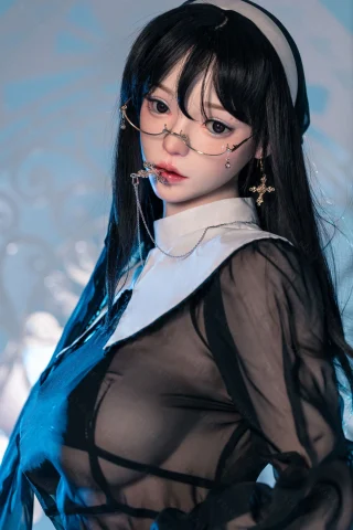 Subject features long black hair, wearing a sheer black outfit with a white collar. Accessories include glasses and decorative chains. The setting has a soft blue light.