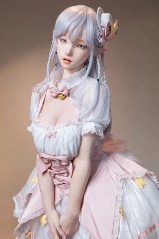 Doll features soft pastel colors, a frilly dress with a large bow, and star accents. Hair is long, light, and styled with braids.