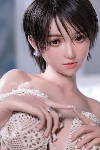 Subject with short dark hair, wearing a delicate lace garment. Soft facial features and a subtle expression, hands delicately positioned.