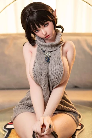 Subject features long dark hair, pointed ears, and a cozy knitted dress. The setting is a softly lit room with a relaxed atmosphere.