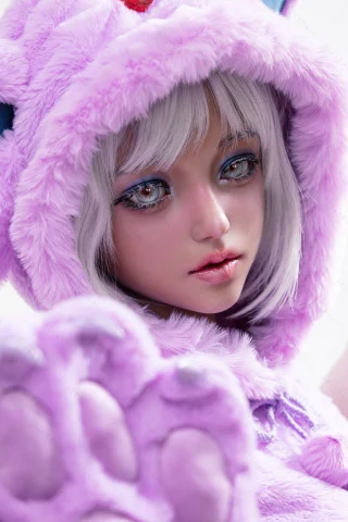 Soft purple plush outfit with a hood, featuring cute ears. Big, expressive eyes and short white hair create a whimsical look.