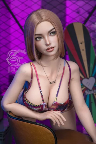 A doll with short blonde hair and green eyes sits in a chair, wearing a colorful bikini top and a necklace, against a purple-lit background.