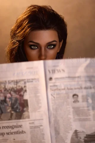 R8 150cm Dark Tanned RealLady ROS Max Series doll reading a newspaper with striking features and realistic details.