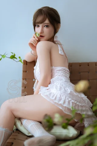 SES069-T163-C-Head138SO-MayaB-3 doll in a delicate outfit, showcasing lifelike features and a serene pose.