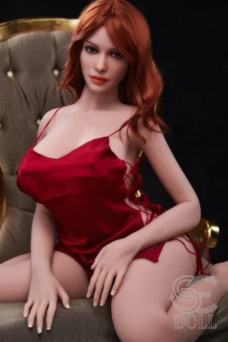 Realistic SED250-157-H-Head-090-Madeline doll in a red satin outfit, seated elegantly on a plush chair.