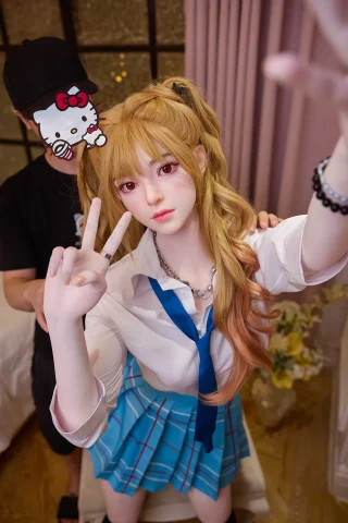 Asuka Eva 163cm C-Cup doll wearing a school uniform with a blue skirt and white shirt, posing peace sign.