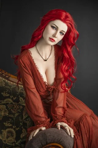 Eva 171cm C-Cup Starpery in a red dress with a plunging neckline, seated on a vintage couch with long red hair.