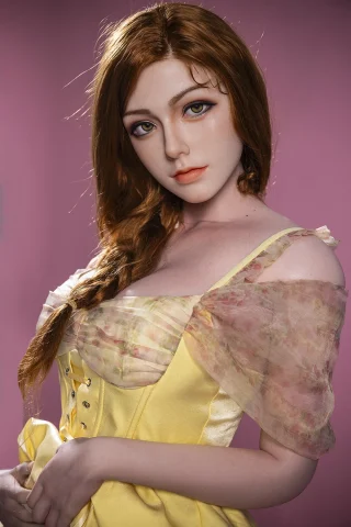 Julie 172cm F-Cup Starpery doll with long brown hair, wearing a yellow dress with a sheer overlay against a pink background.