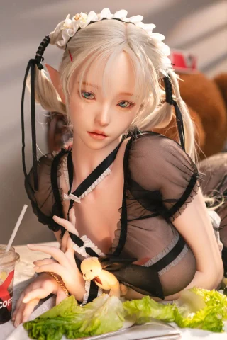 Calla doll 155cm with long blonde hair and a maid outfit, sitting at a table with lettuce and a drink.